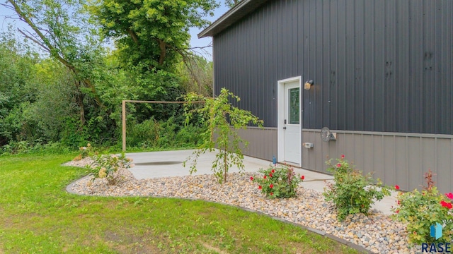 view of property exterior with a lawn and a patio