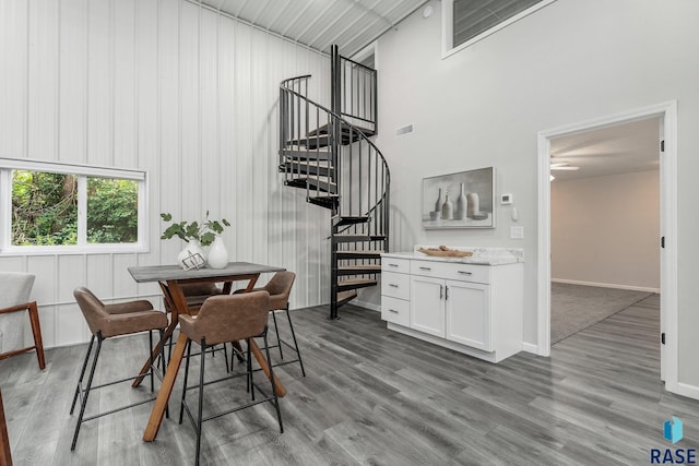 dining room with wood-type flooring and a high ceiling