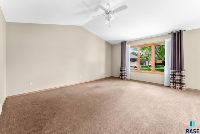 carpeted spare room featuring ceiling fan and vaulted ceiling