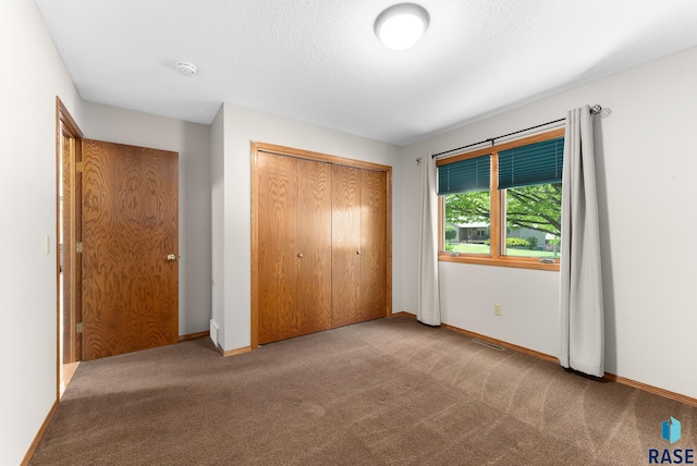 unfurnished bedroom with light carpet and a closet