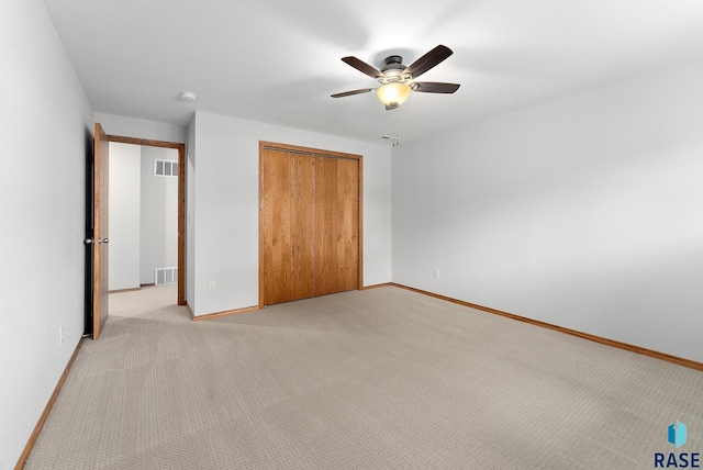 unfurnished bedroom with ceiling fan, a closet, and light colored carpet