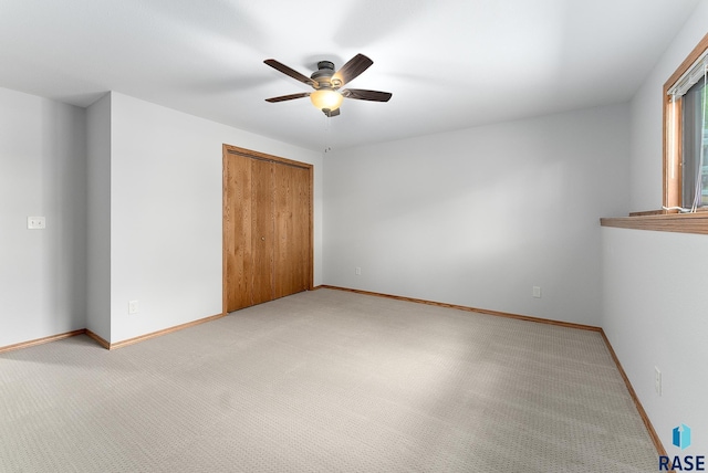 unfurnished bedroom with light carpet, a closet, and ceiling fan