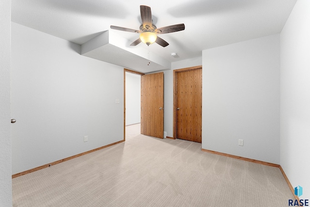carpeted spare room with ceiling fan