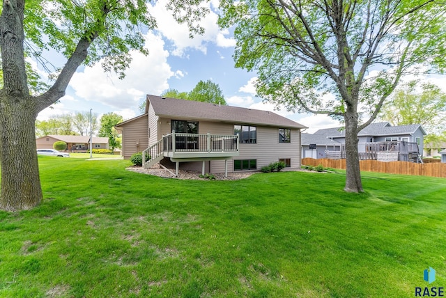 back of property with a yard and a deck