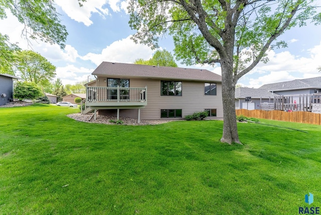 back of property with a yard and a deck