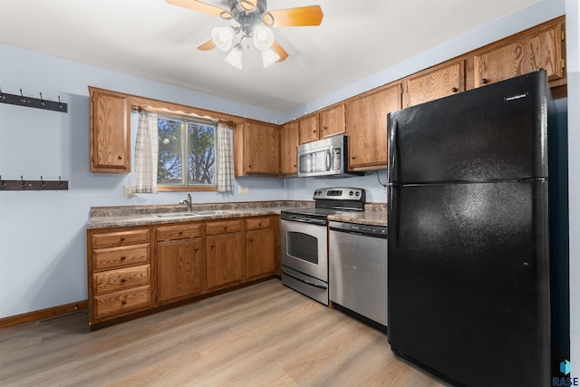 kitchen featuring ceiling fan, sink, light hardwood / wood-style flooring, and appliances with stainless steel finishes