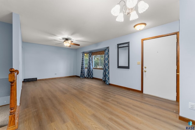 entrance foyer featuring ceiling fan with notable chandelier and light hardwood / wood-style flooring