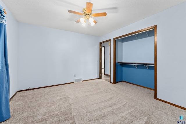 unfurnished bedroom featuring ceiling fan, light colored carpet, and a closet