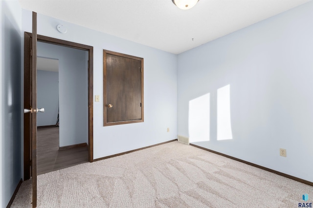 unfurnished bedroom featuring a closet and light colored carpet