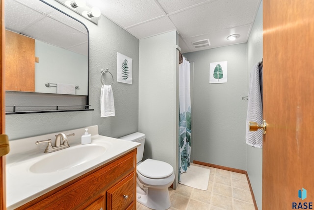 bathroom featuring vanity, toilet, and a paneled ceiling