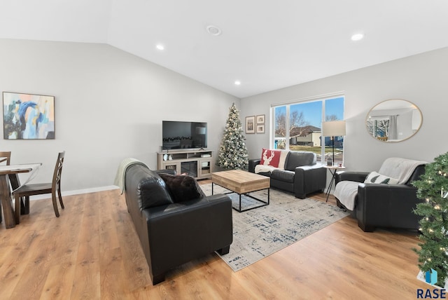 living room featuring vaulted ceiling and light wood-type flooring