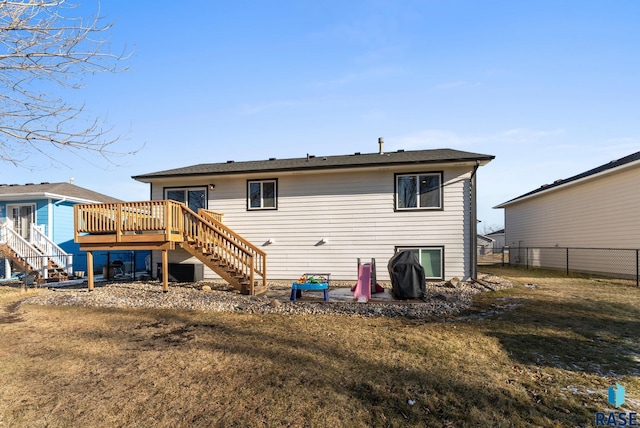 rear view of house featuring a lawn and a deck