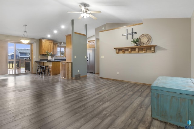 kitchen featuring a wealth of natural light, ceiling fan, a kitchen breakfast bar, stainless steel fridge with ice dispenser, and lofted ceiling