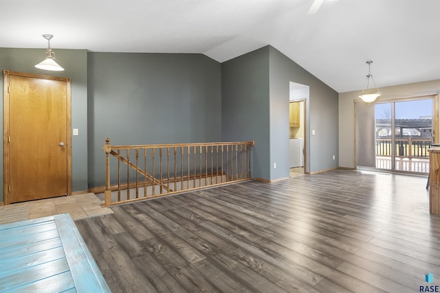 interior space with hardwood / wood-style flooring, washer / clothes dryer, and vaulted ceiling