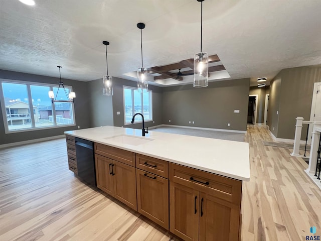 kitchen featuring ceiling fan with notable chandelier, black dishwasher, sink, hanging light fixtures, and a healthy amount of sunlight