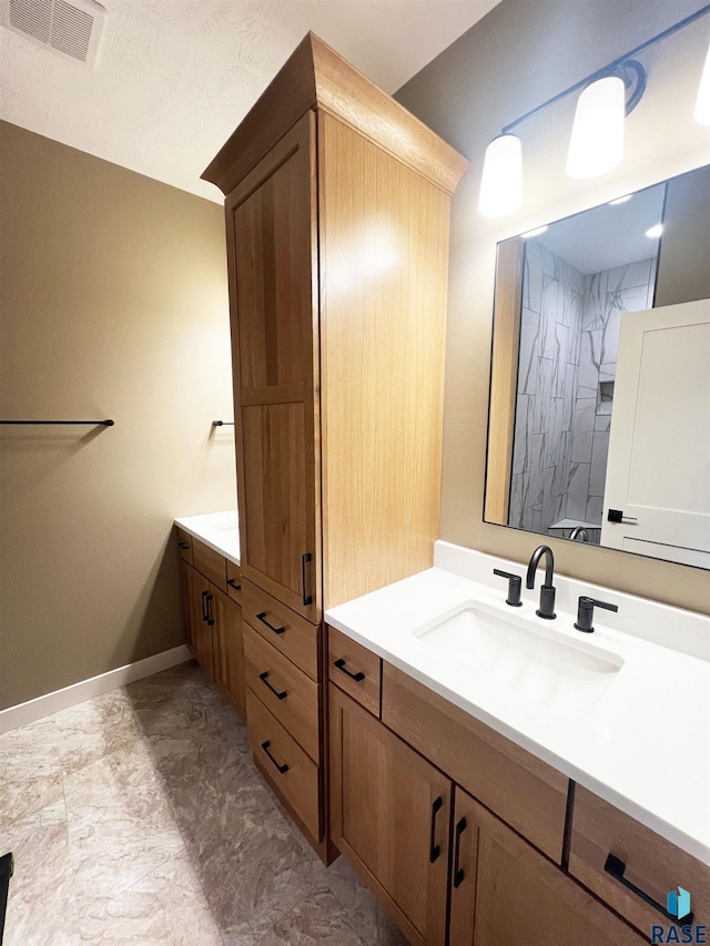 bathroom with vanity and a shower