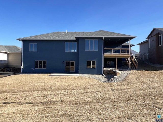 back of house featuring a wooden deck and a patio