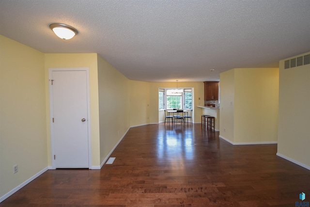 spare room featuring a textured ceiling and dark wood-type flooring