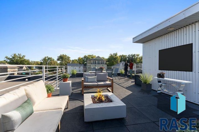 view of patio with an outdoor living space with a fire pit