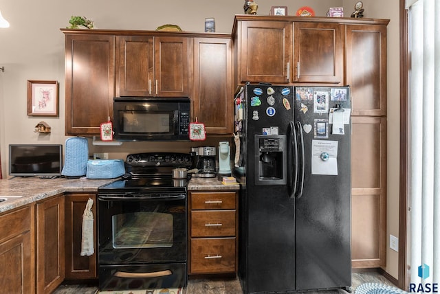 kitchen featuring light stone counters and black appliances