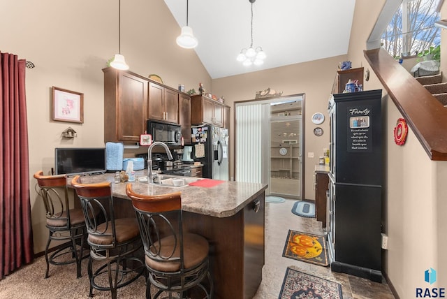 kitchen with dark brown cabinetry, sink, hanging light fixtures, an inviting chandelier, and refrigerator with ice dispenser