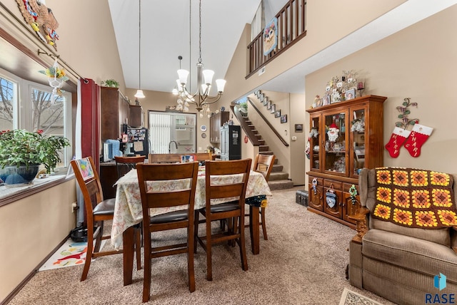 carpeted dining space featuring sink, high vaulted ceiling, and an inviting chandelier