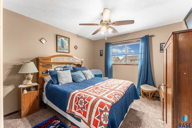 carpeted bedroom featuring ceiling fan and a textured ceiling