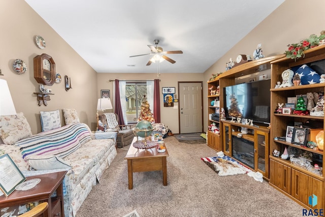 carpeted living room with ceiling fan and a fireplace