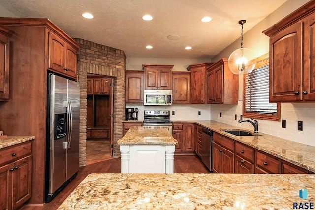 kitchen with appliances with stainless steel finishes, light stone countertops, dark wood-type flooring, sink, and decorative light fixtures