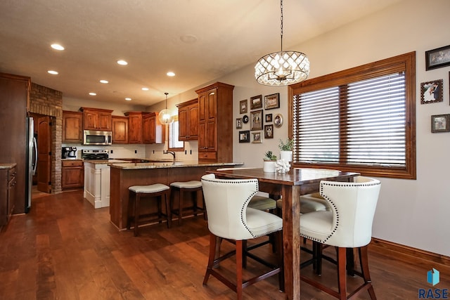 dining space with sink, dark wood-type flooring, and a chandelier