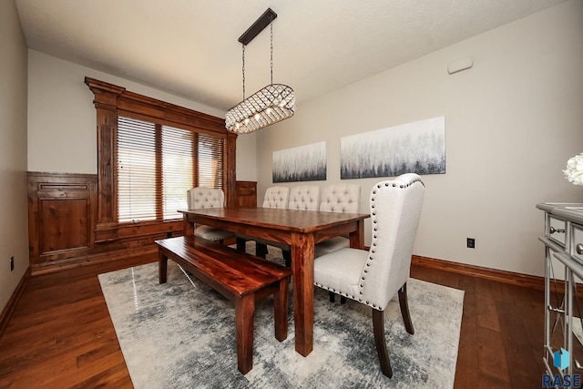 dining area with a notable chandelier and dark wood-type flooring