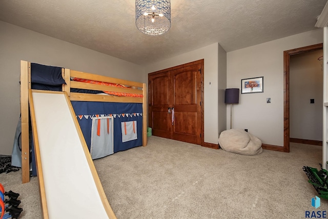 bedroom featuring a textured ceiling and light carpet