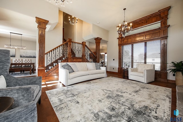 living room with a high ceiling, decorative columns, and dark hardwood / wood-style floors