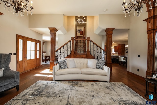 living room with a high ceiling, dark hardwood / wood-style flooring, and decorative columns