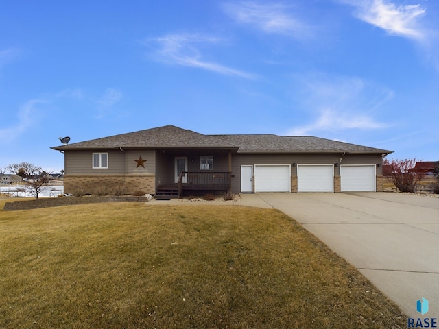 view of front of home featuring covered porch, a garage, and a front lawn