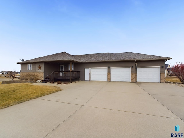 view of front facade featuring a garage, a deck, and a front yard