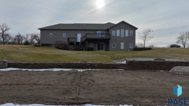 rear view of property featuring a wooden deck and a yard