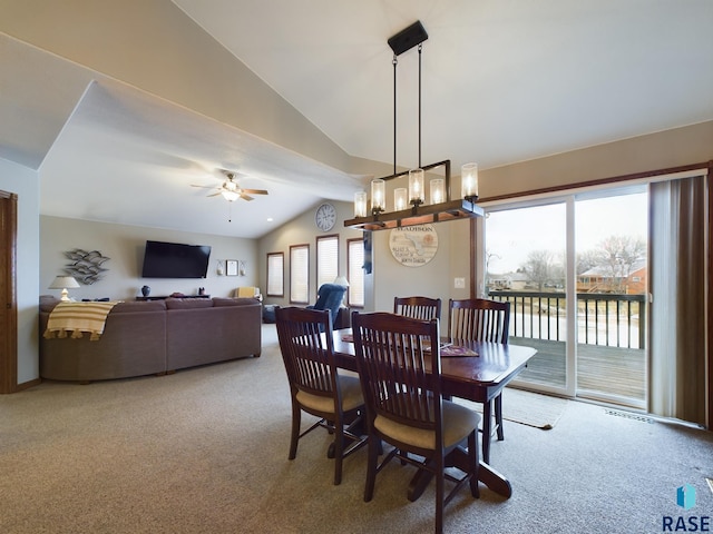 carpeted dining room with ceiling fan and vaulted ceiling