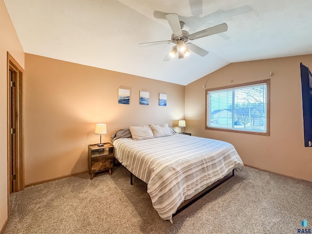 carpeted bedroom with ceiling fan and vaulted ceiling