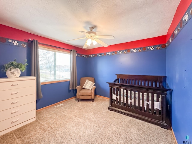 carpeted bedroom with ceiling fan and a textured ceiling