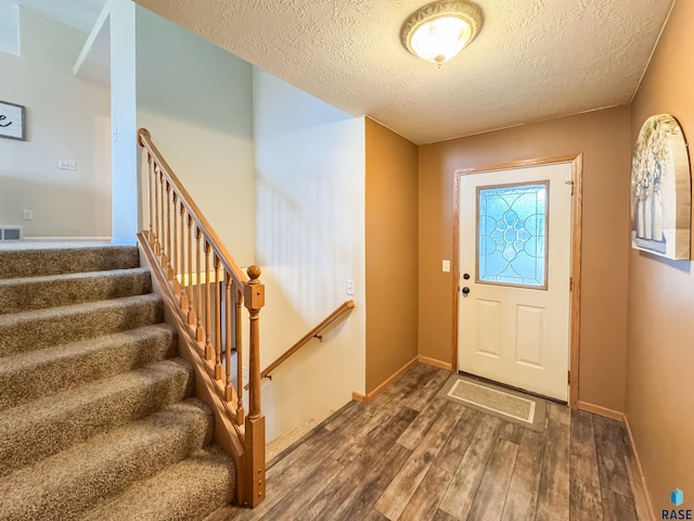 foyer featuring a textured ceiling and dark hardwood / wood-style floors