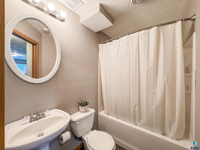 full bathroom with a textured ceiling, toilet, shower / bath combo with shower curtain, and sink