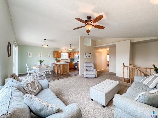 living room with ceiling fan, sink, and vaulted ceiling