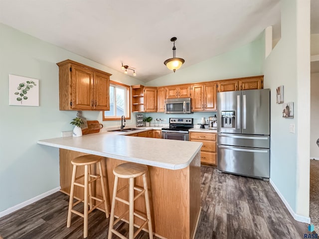 kitchen featuring sink, hanging light fixtures, stainless steel appliances, kitchen peninsula, and lofted ceiling