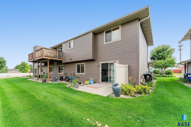 back of property with a lawn, a patio area, a wooden deck, and central air condition unit