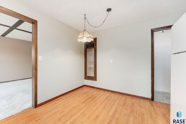 unfurnished room with wood-type flooring and a notable chandelier