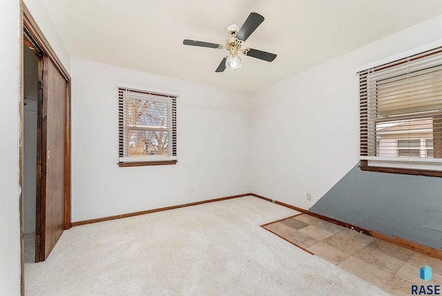 unfurnished room with ceiling fan and light carpet