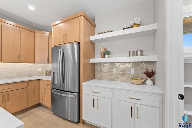 kitchen with stainless steel fridge with ice dispenser, backsplash, light hardwood / wood-style floors, and light brown cabinetry