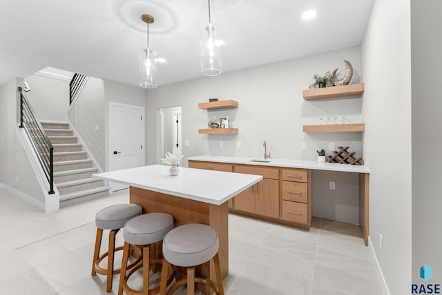 kitchen with sink, a center island, hanging light fixtures, and light tile patterned floors