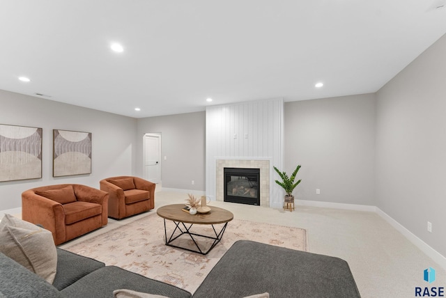 living room with a tiled fireplace and light colored carpet